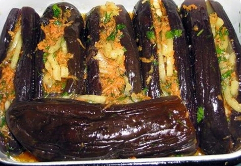 inlagda aubergine med morötter, örter och vitlök i en tallrik